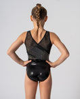 Carica l'immagine nel visualizzatore della galleria, Back view of a young girl in a black leotard with a shimmering design
