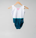 Load image into Gallery viewer, Colorful leotard hanging on a wooden hanger, featuring a white top and teal bottom with a pink accent.
