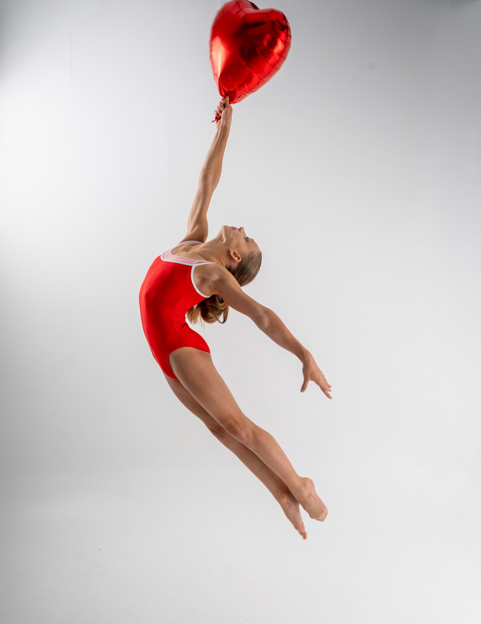 A Picture of the Carina Leotard Jumping With a Balloon